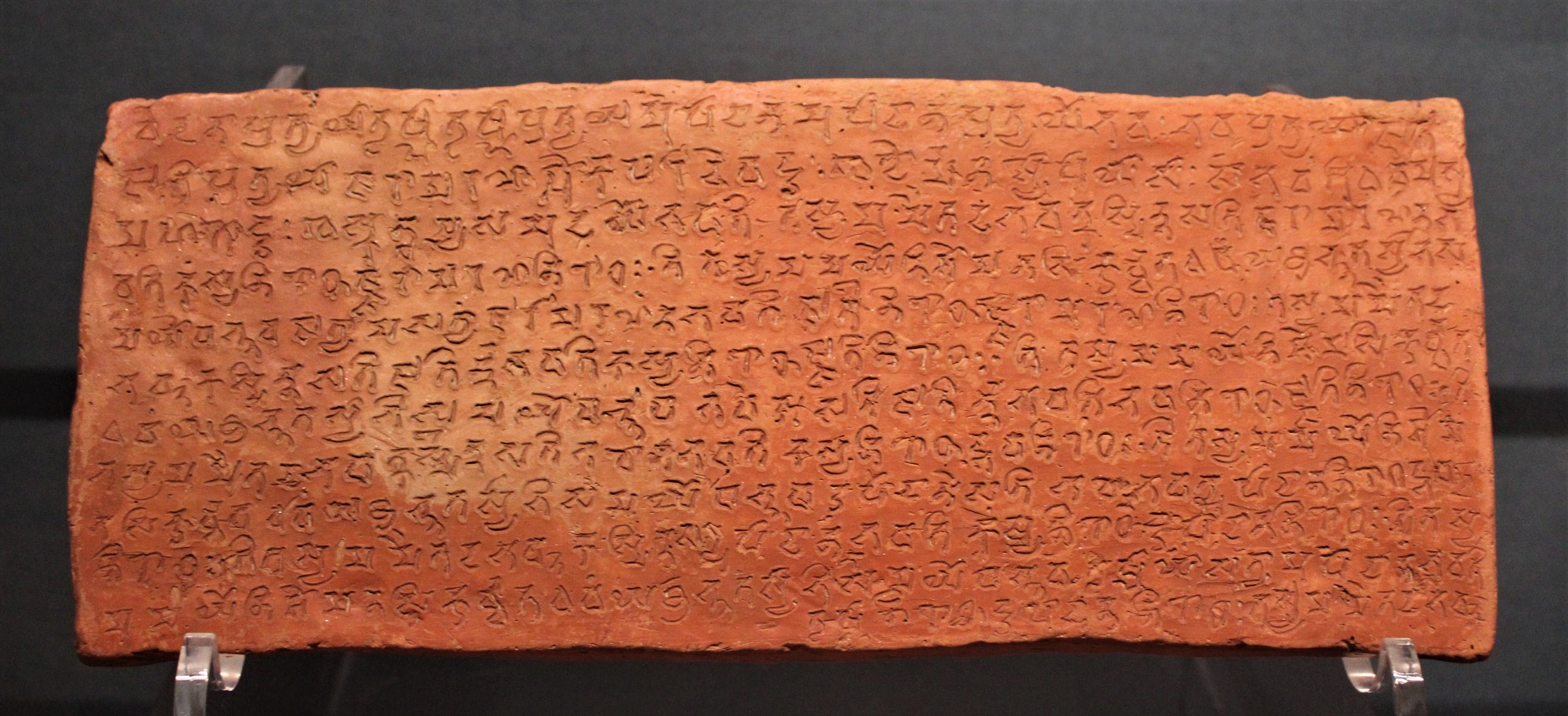 A terracotta brick inscribed in Sanskrit with the dependent-origination verse, dated to about 500 CE.